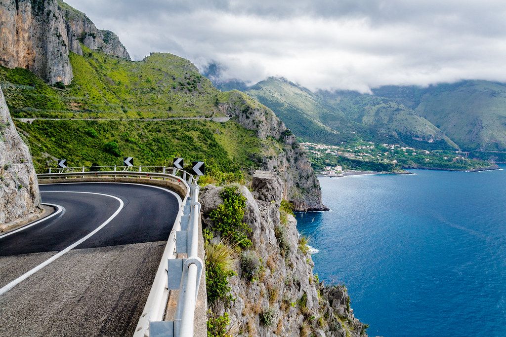 Una strada a tornanti scavata nella roccia sopra il mare